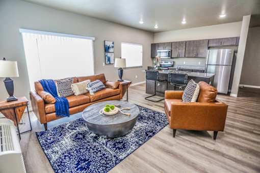 A living room with a brown couch and a blue rug.