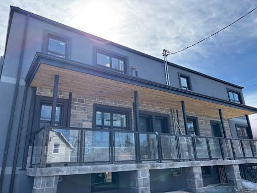 A modern house with a balcony and a glass railing.