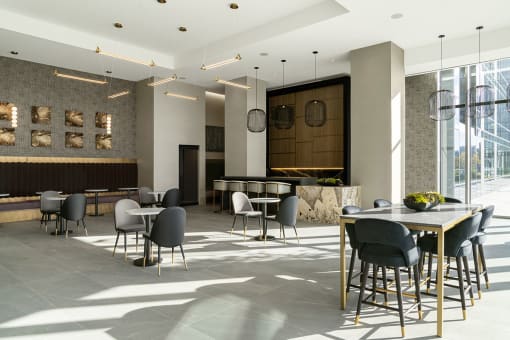 Interior photo of the club room showing multiple seating areas, dramatic lighting and large tile flooring.