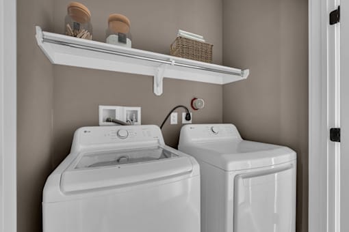 A white washing machine and dryer in a laundry room.