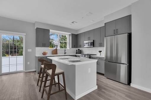 A modern kitchen with a large island and stainless steel appliances.