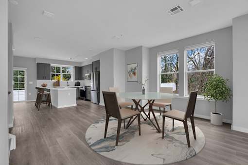 A modern kitchen with a dining table and chairs.