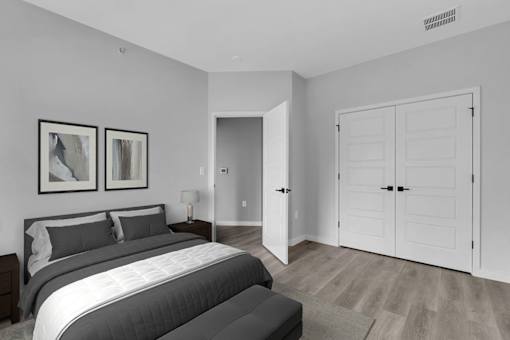 A bedroom with a large bed and two framed pictures on the wall.