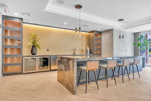 A modern kitchen with a bar area and wooden flooring.