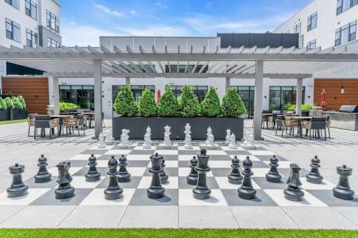 A giant chess board sits in the middle of a courtyard.