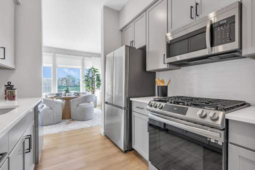 A modern kitchen with stainless steel appliances and a large window.
