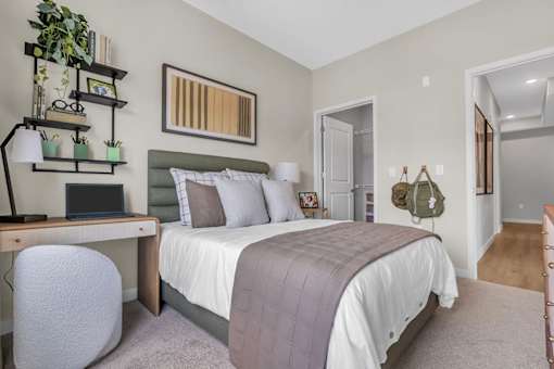A bedroom with a bed, desk, and chair.