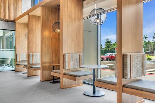 A modern waiting area with wooden furniture and a glass wall.