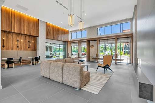 A modern living room with a large sectional sofa and a wooden accent wall.