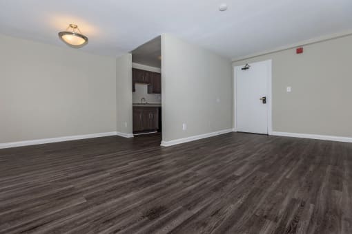 an empty living room with a kitchen in the background at Highland Ridge, Capitol Heights