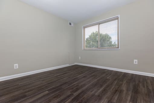 a bedroom with hardwood floors and a large window at Highland Ridge, Capitol Heights, 20743