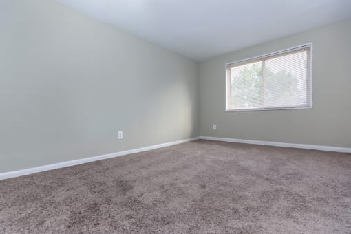 an empty bedroom with a large window and carpet at Highland Ridge, Capitol Heights, 20743