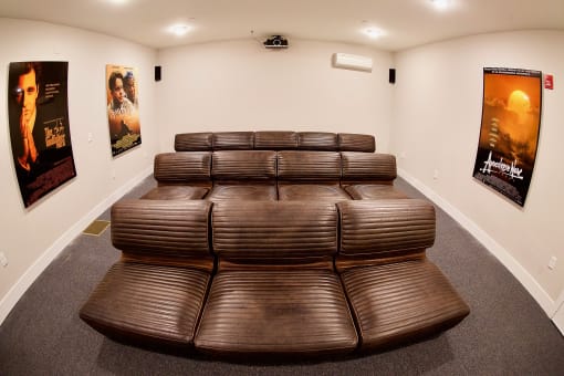 a theater room with large brown leather seating at The Lofts at Middlesex, the perfect in  house cinema