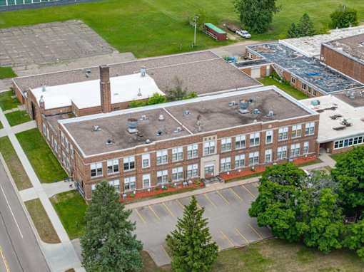 A large brick building with a parking lot in front.