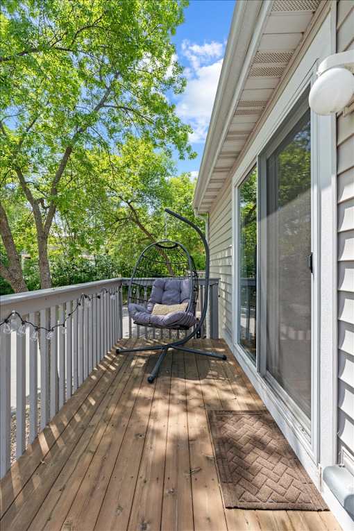 A wooden deck with a chair and table.