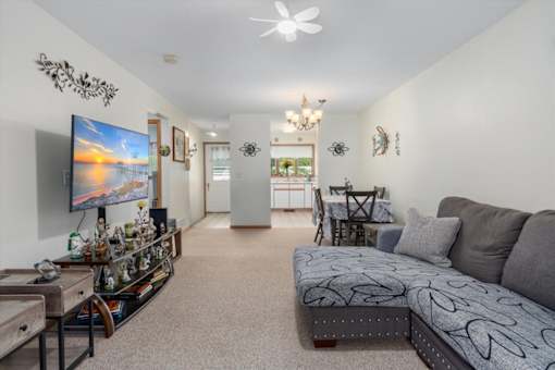 A living room with a grey couch and a television on the wall.