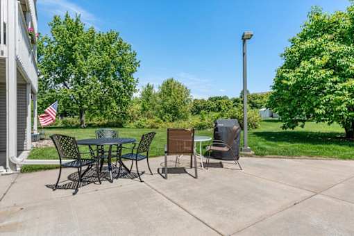 A patio with a table and chairs and an American flag.
