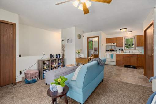 A living room with a blue couch and a ceiling fan.