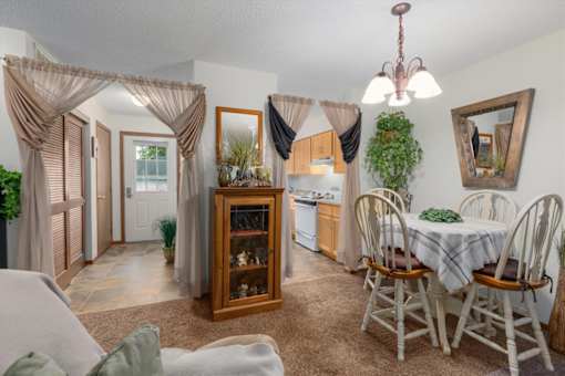 A dining room with a table set for four.