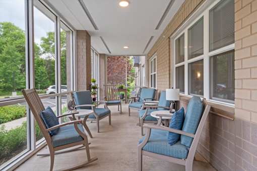 A row of chairs are lined up on a patio.