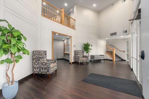 A living room with a wooden floor and a staircase.