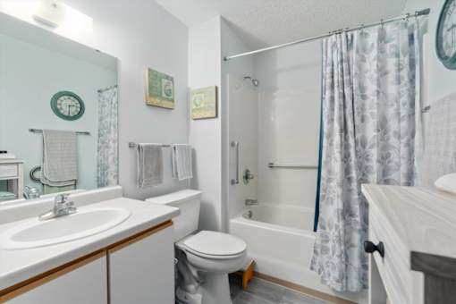 A bathroom with a toilet, sink, and shower.