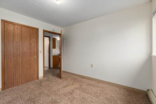 A room with a brown door and a white wall.