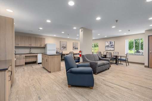 A spacious living room with a kitchen area in the background.