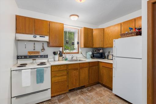 A kitchen with wooden cabinets and a white refrigerator.