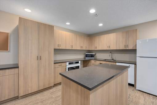 A kitchen with wooden cabinets and a black countertop.