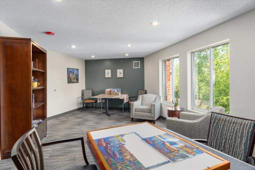 A room with a table and chairs and a quilt on the table.