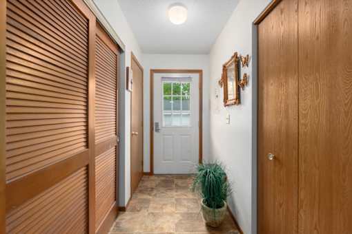 A hallway with wooden doors and a potted plant.