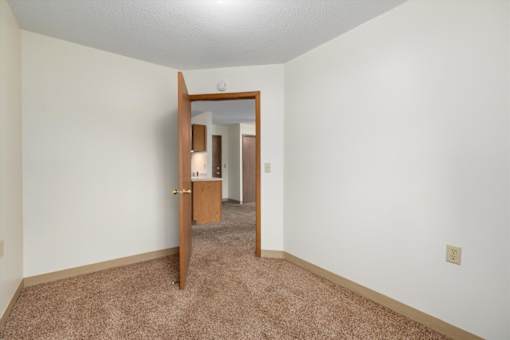 A room with a carpeted floor and a mirror on the wall.