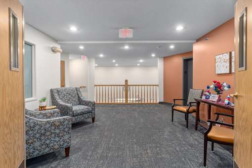 A waiting room with chairs and a crib in the background.