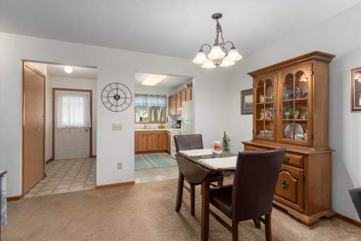 A dining room with a wooden table and chairs.