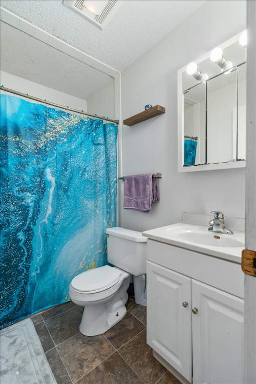 A white toilet sits next to a sink in a bathroom.