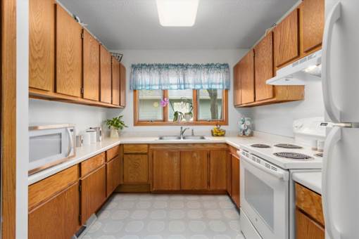 A kitchen with wooden cabinets and white appliances.