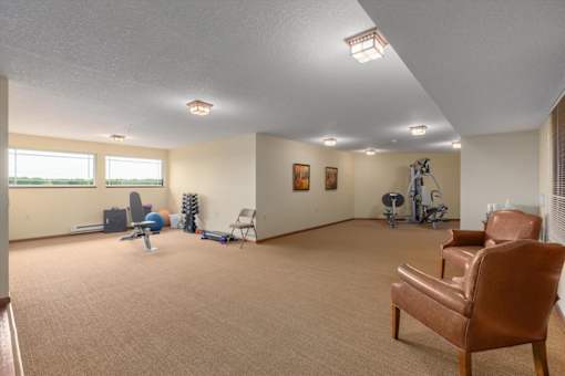 A room with a brown chair and exercise equipment.