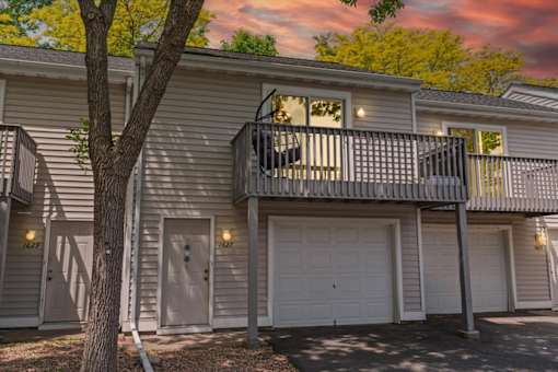 A two-story house with a balcony and garage doors.