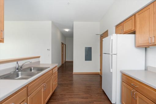 A kitchen with wooden cabinets and a white fridge.
