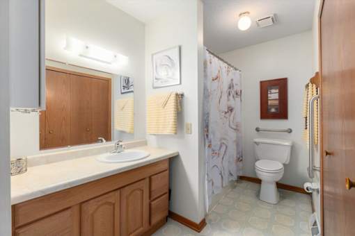 A bathroom with a toilet, sink, and shower.