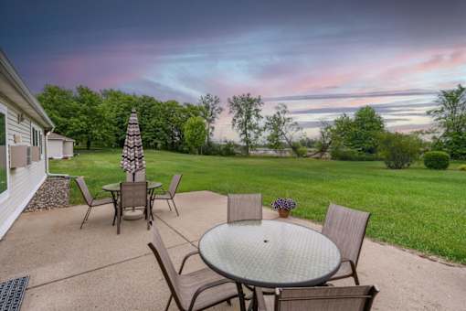 A patio with a table and chairs is set up for an evening outside.