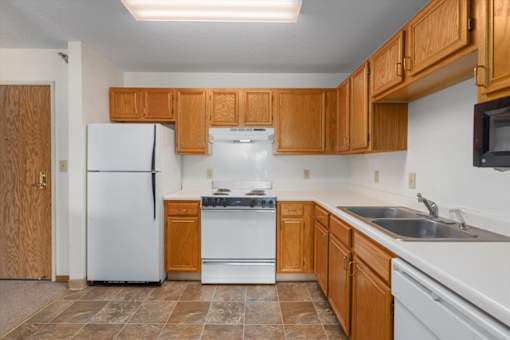 A kitchen with wooden cabinets and a white refrigerator.