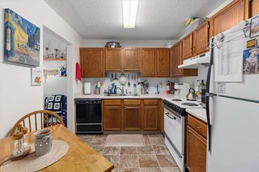 A kitchen with wooden cabinets and white appliances.