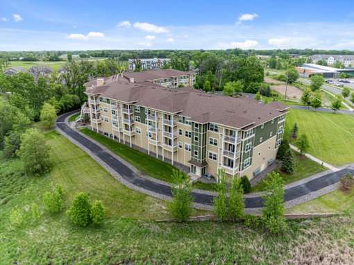 A large apartment complex with a curved driveway in front.