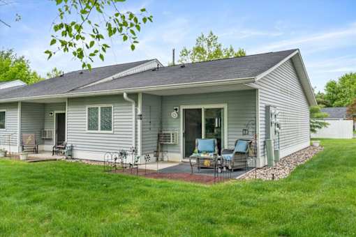 A house with a grey roof and a green lawn.