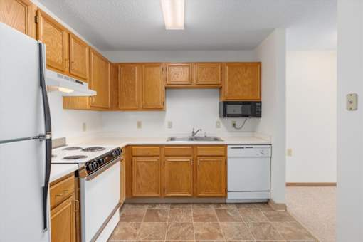 A kitchen with wooden cabinets and white appliances.