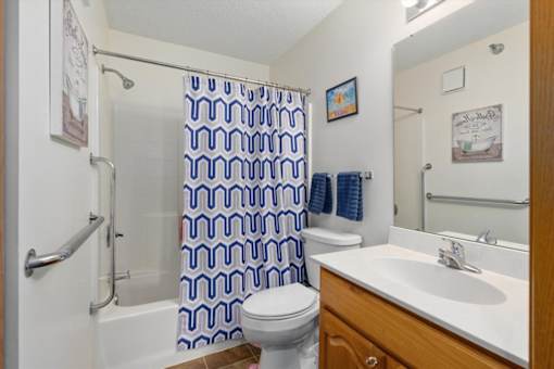 A bathroom with a toilet, sink, and shower curtain.