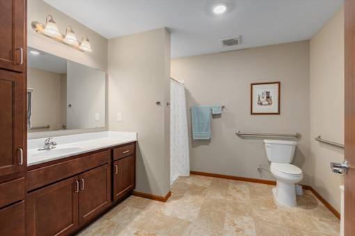 A bathroom with a toilet, sink, and a mirror.
