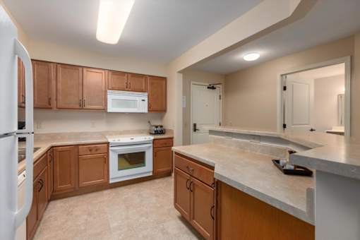A kitchen with wooden cabinets and a white refrigerator.